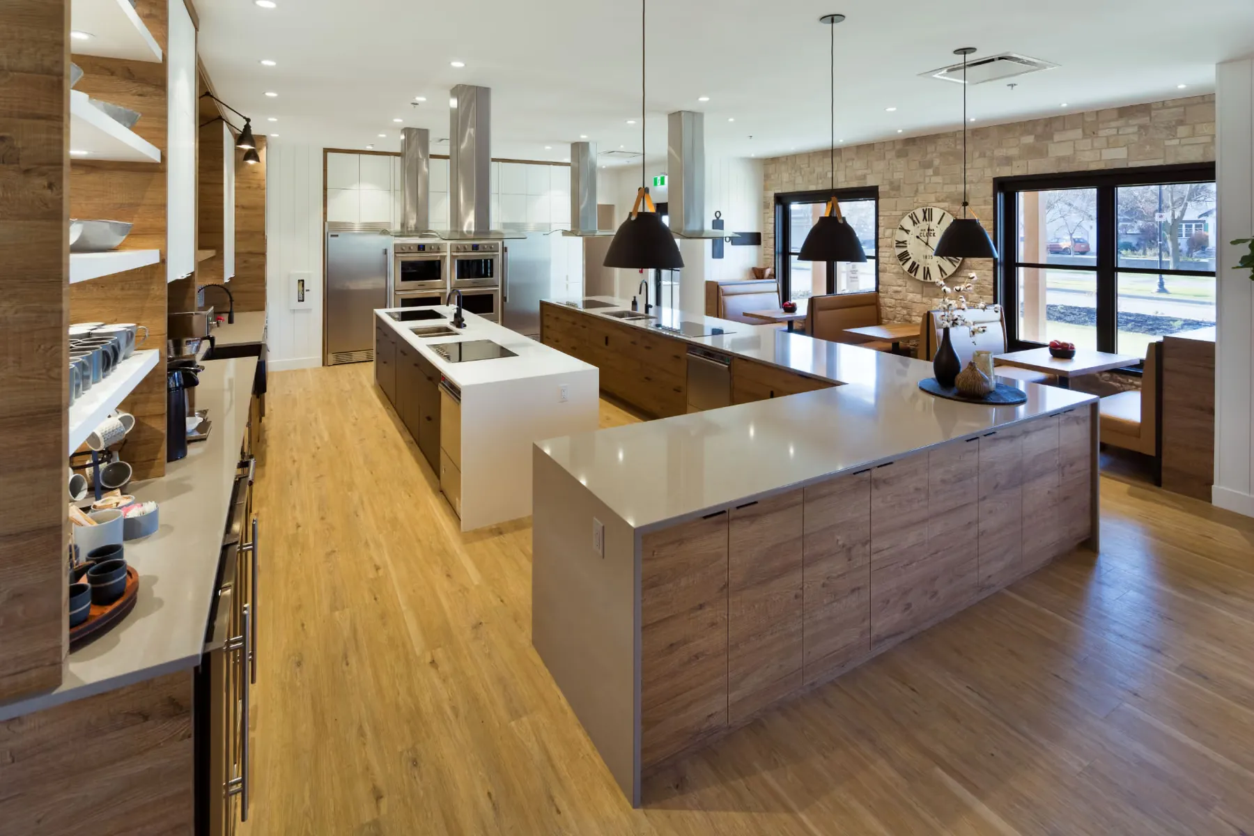 Open communal kitchen and dining area with oak island seating and custom casework
