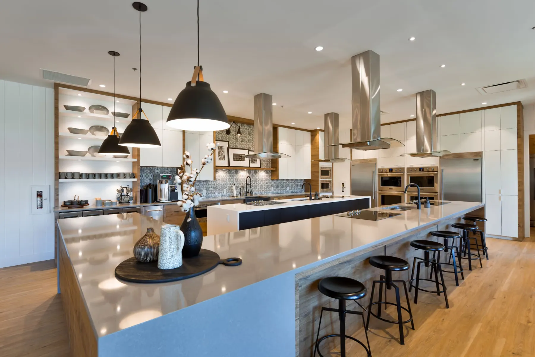 High-end residential kitchen with a full-height oak island and stainless range hoods