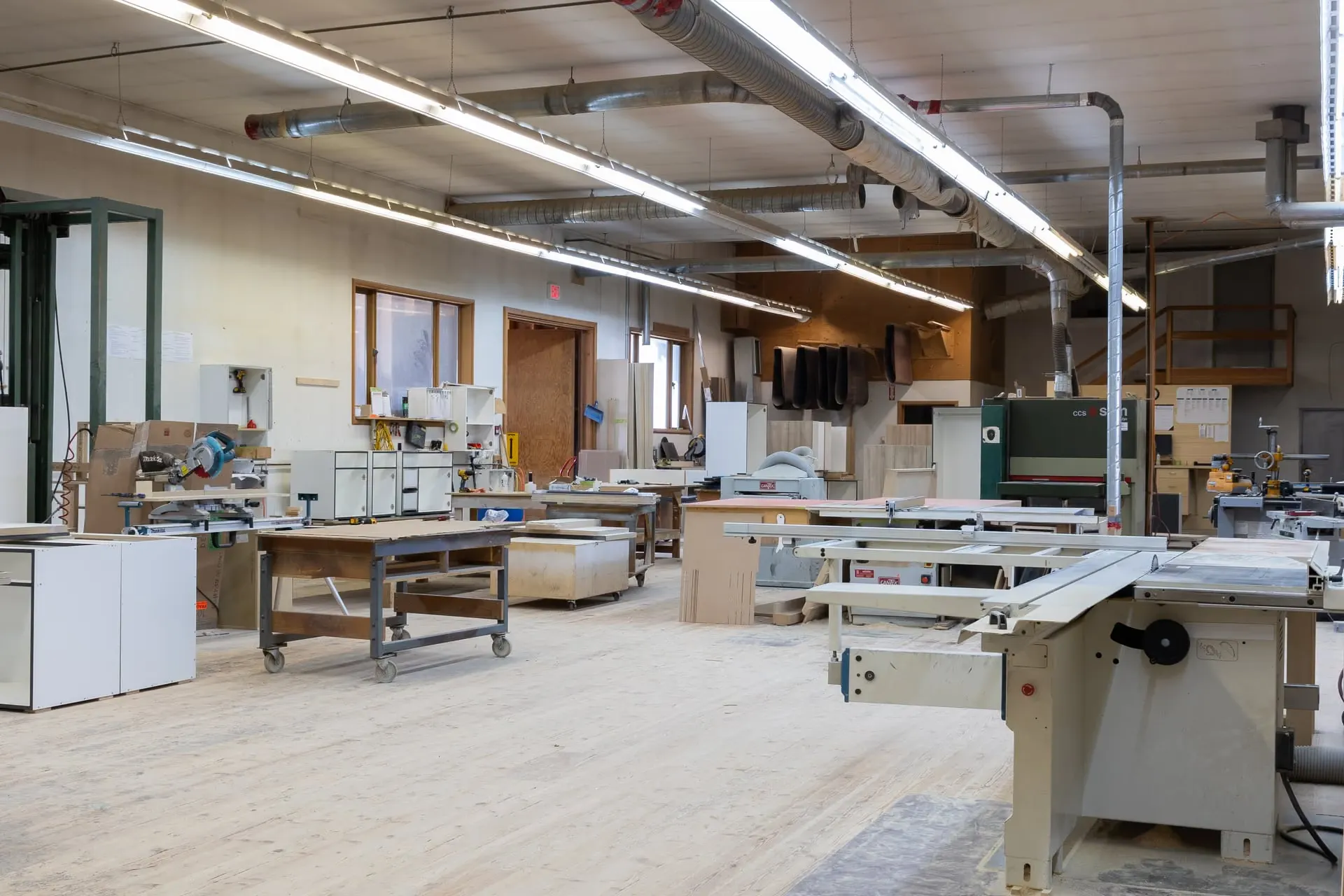 The P5 Millwork shop floor with a sliding table saw, wide-belt sander and cabinet boxes in build